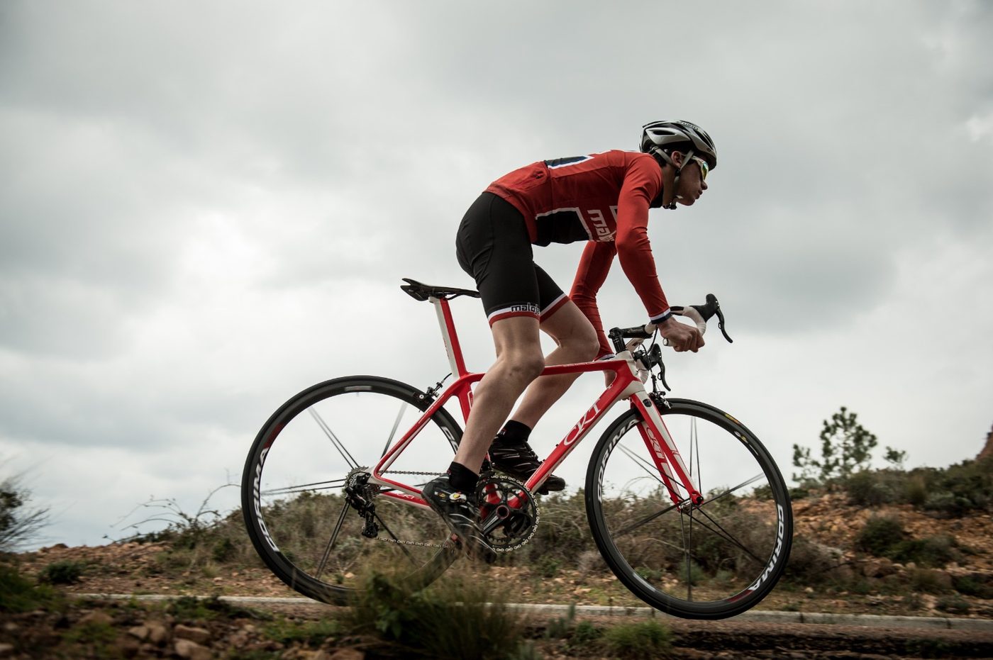 Cycliste sur un vélo de route carbone CKT rouge et blanc